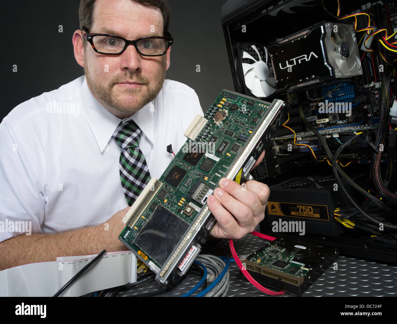 Mann mit Computer und verschiedenen Hardware-Komponenten Stockfoto