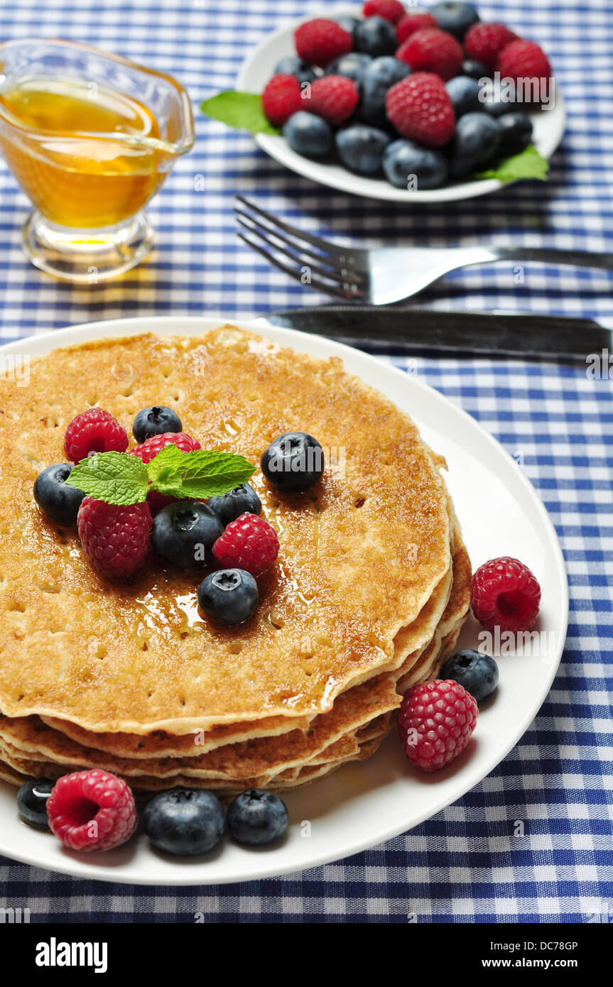 Leckere Pfannkuchen hautnah, mit frischen Heidelbeeren, Himbeeren und Ahornsirup Pfannkuchen mit frischen Beeren Stockfoto