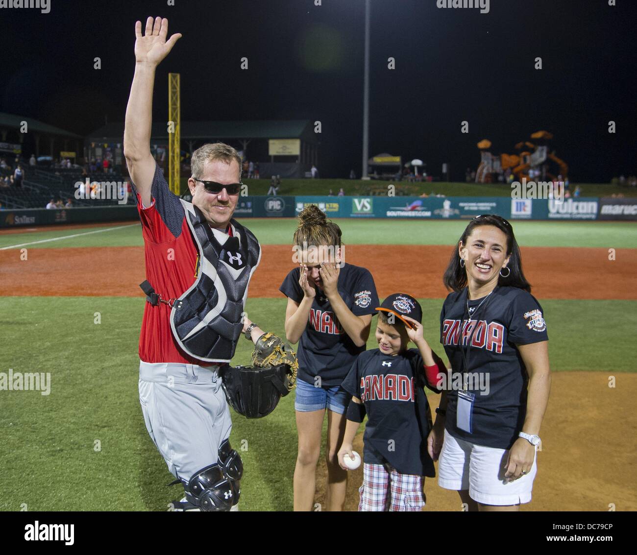 10. August 2013 - Aberdeen, Maryland, USA - The Byars Kinder reagieren die Überraschung Rückkehr vom Einsatz in Kuwait ihres Vaters Edward als ihre Mutter, die Marion blickt auf. Bryce, 6, warf den ersten Pitch vor dem Abendspiel an der Cal Ripken World Series zu seinem Vater, gekleidet als Blickfang aus der Maryland State Champion. Brianna, 13, und Bryce waren mit Emotionen überwinden, wenn Edward seine Fänger Maske entfernt. Die Überraschung Rückkehr erfolgte vor Maryland State Mountain Home, AR an der Cal Ripken World Series in Aberdeen, Maryland am 10. August 2013 gespielt. (Kredit-Bild: © Scott Se Stockfoto