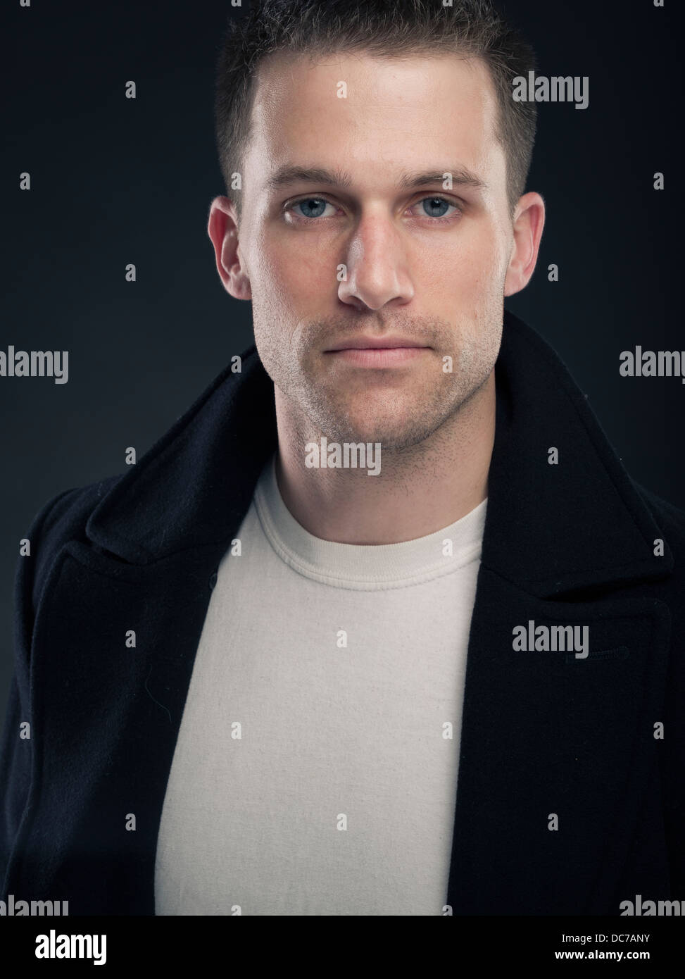 Hübscher kaukasischen Mann in weißem T-shirt und dunklen Wollmantel Erbse (Jacke) Stockfoto