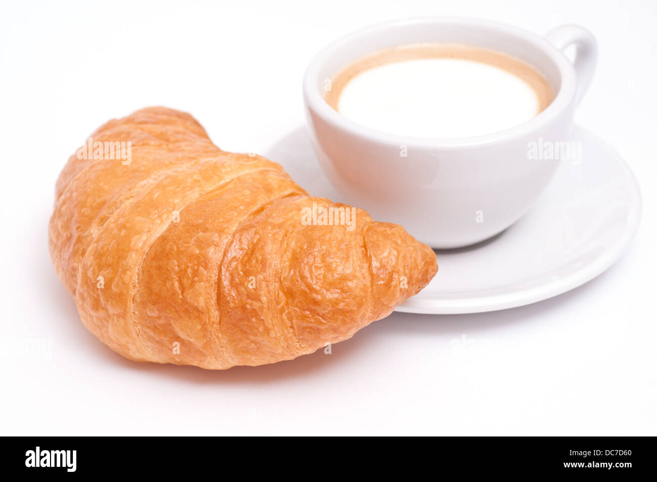 Tasse Cappuccino mit einem französischen Croissant und einem weißen Hintergrund Stockfoto