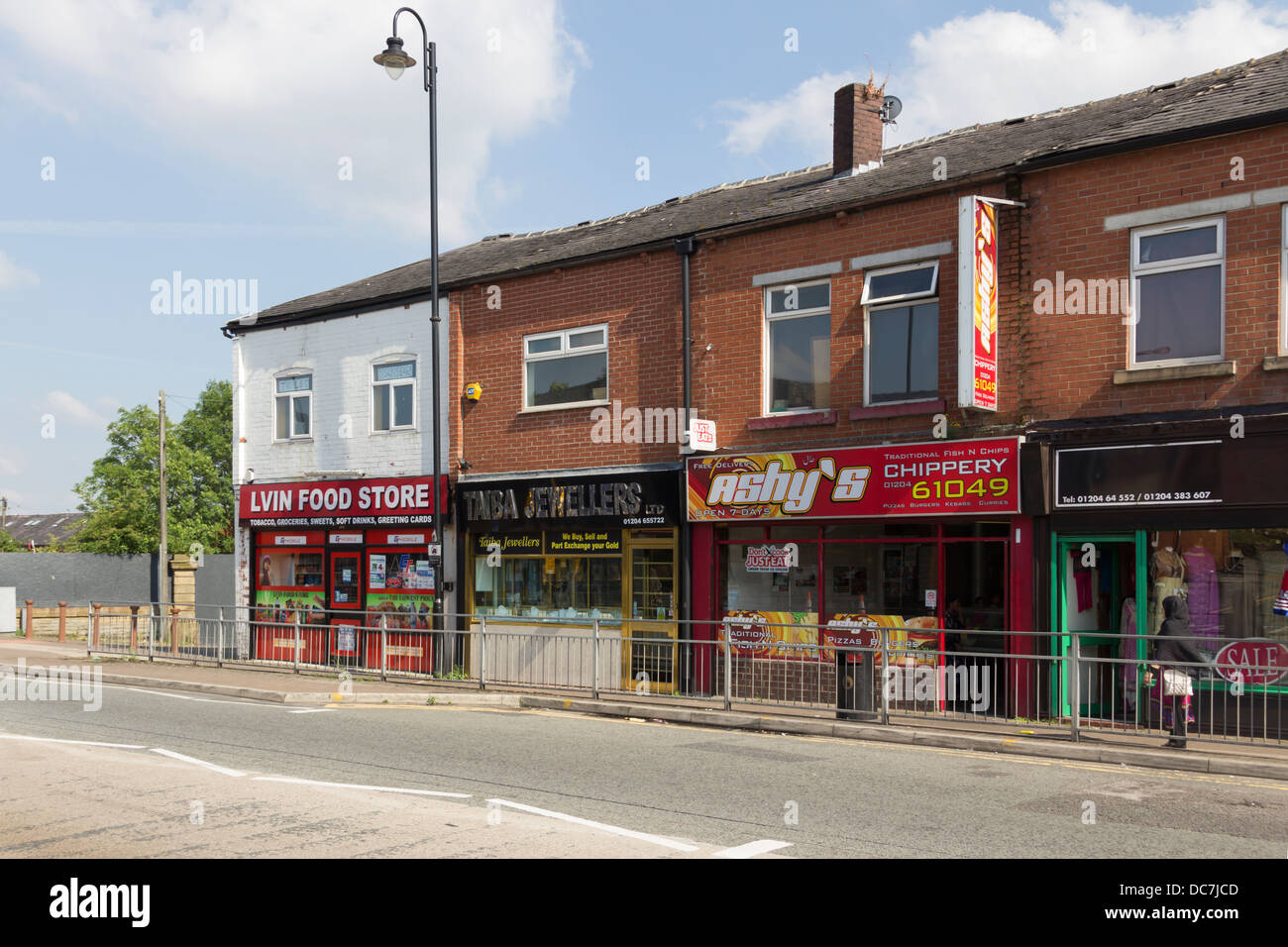 Eine Reihe von gemischten kleinen Läden auf St. Helens Straße im Daubhill Bereich der Bolton spiegelt die starke ethnische Vielfalt der Region. Stockfoto