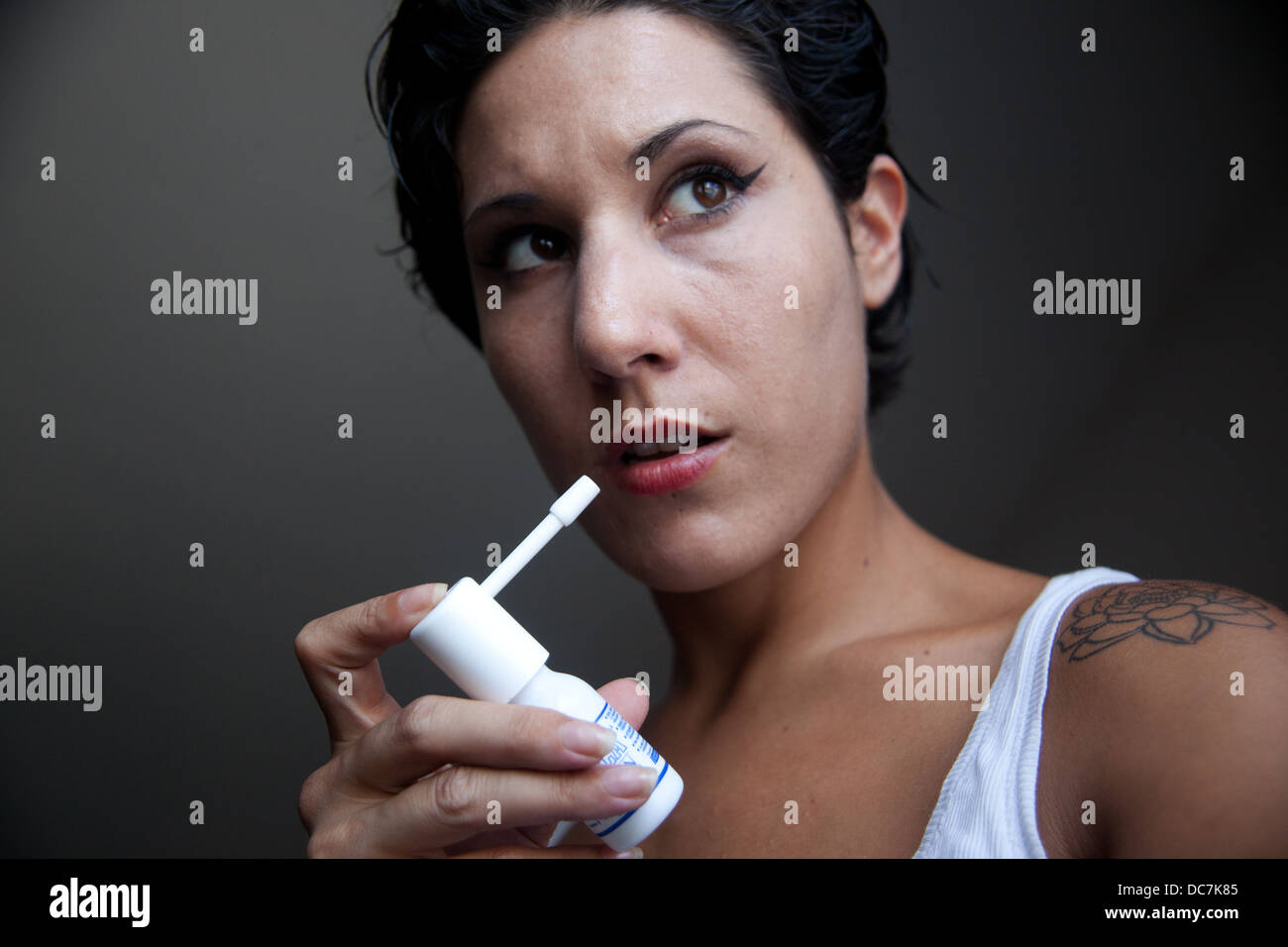 Frau mit Hals-spray Stockfoto