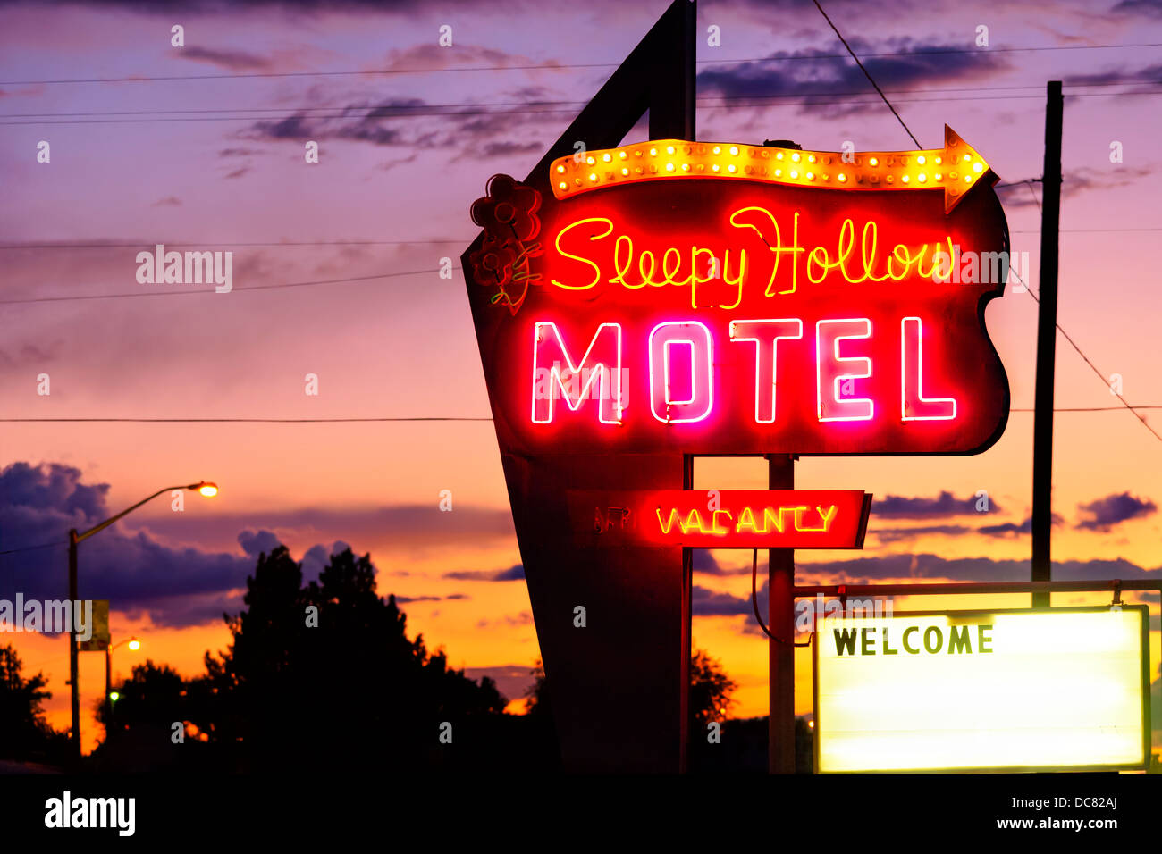 Hellen Neon-Schild für das Sleepy Mulden Motel mit Leerstand und Willkommen Schilder in der Abenddämmerung. Aus der i-70 in Green River UT Stockfoto