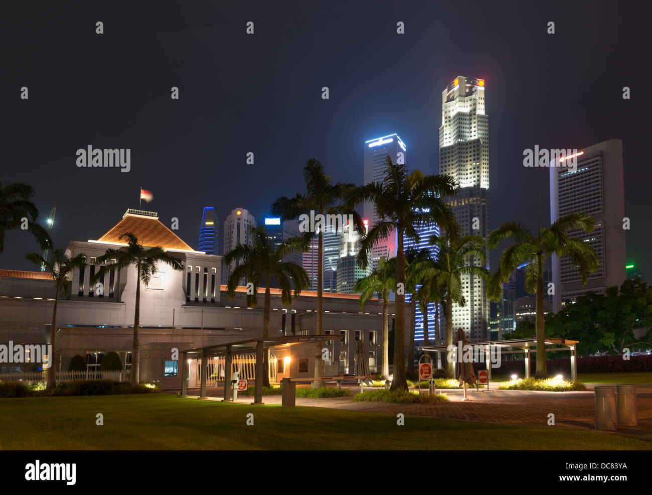 Singapur-Parlamentsgebäude beleuchtet in der Nacht mit Wolkenkratzer auf Hintergrund Stockfoto