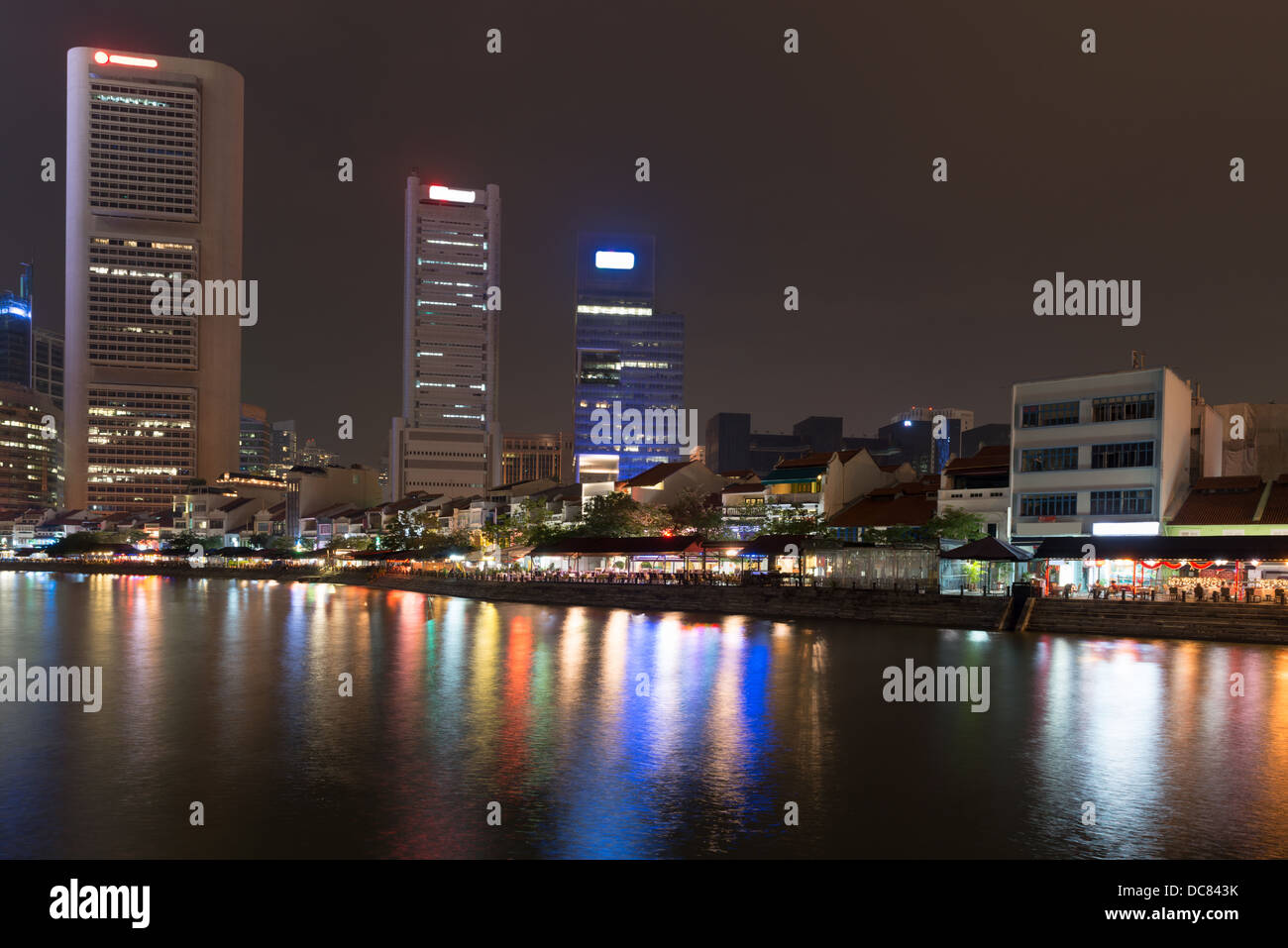 Singapur-Kai in der Nacht mit hohen Wolkenkratzern im central Business District und und kleine Restaurants am Boat Quay Stockfoto