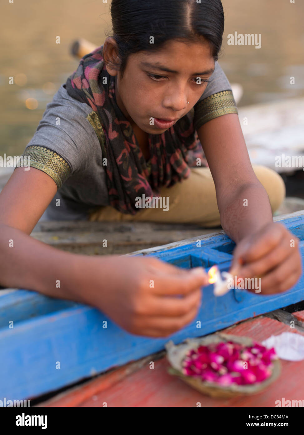Junge Inderin, Verkauf von schwimmenden Kerzen für Touristen auf den Ganges (Varanasi) Stockfoto