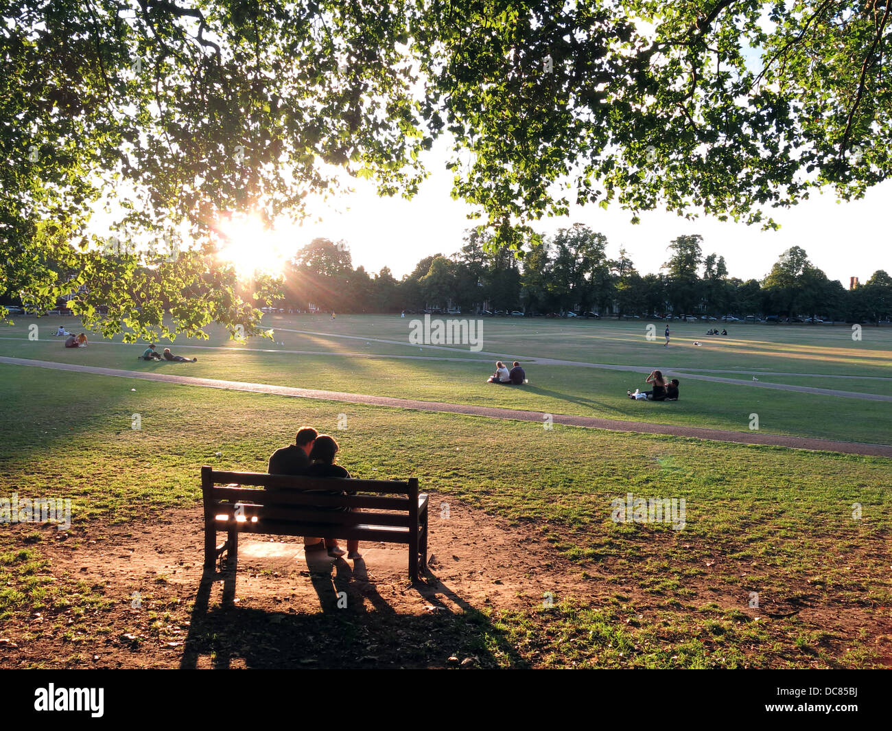 Menschen entspannen auf Richmond grün an einem sonnigen Sommerabend Stockfoto
