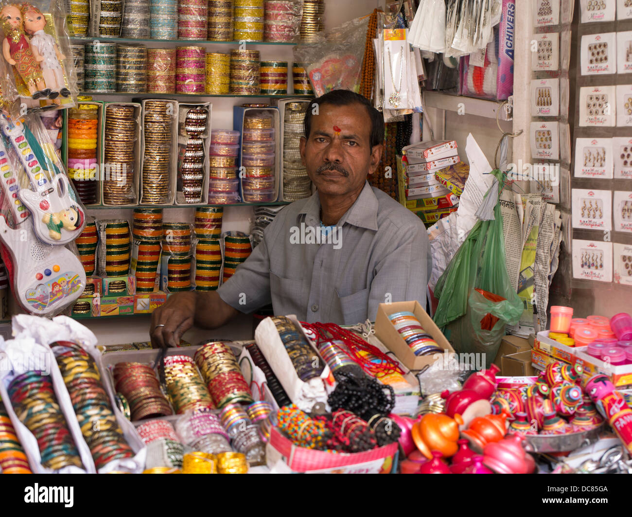 Shop-Betreiber mit roten Tilak auf Stirn Verkauf Armreifen in Varanasi, Indien Stockfoto