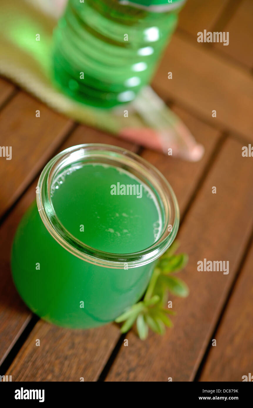 Waldmeister Likör auf einem Holztisch Stockfoto