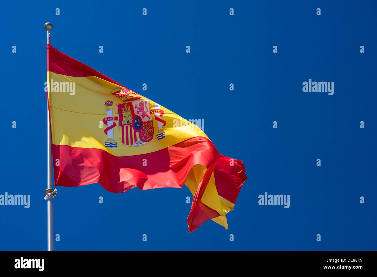 Eine große spanische Nationalflagge fliegt über das Stadtzentrum in Nerja, Andalusien, Südspanien. Stockfoto