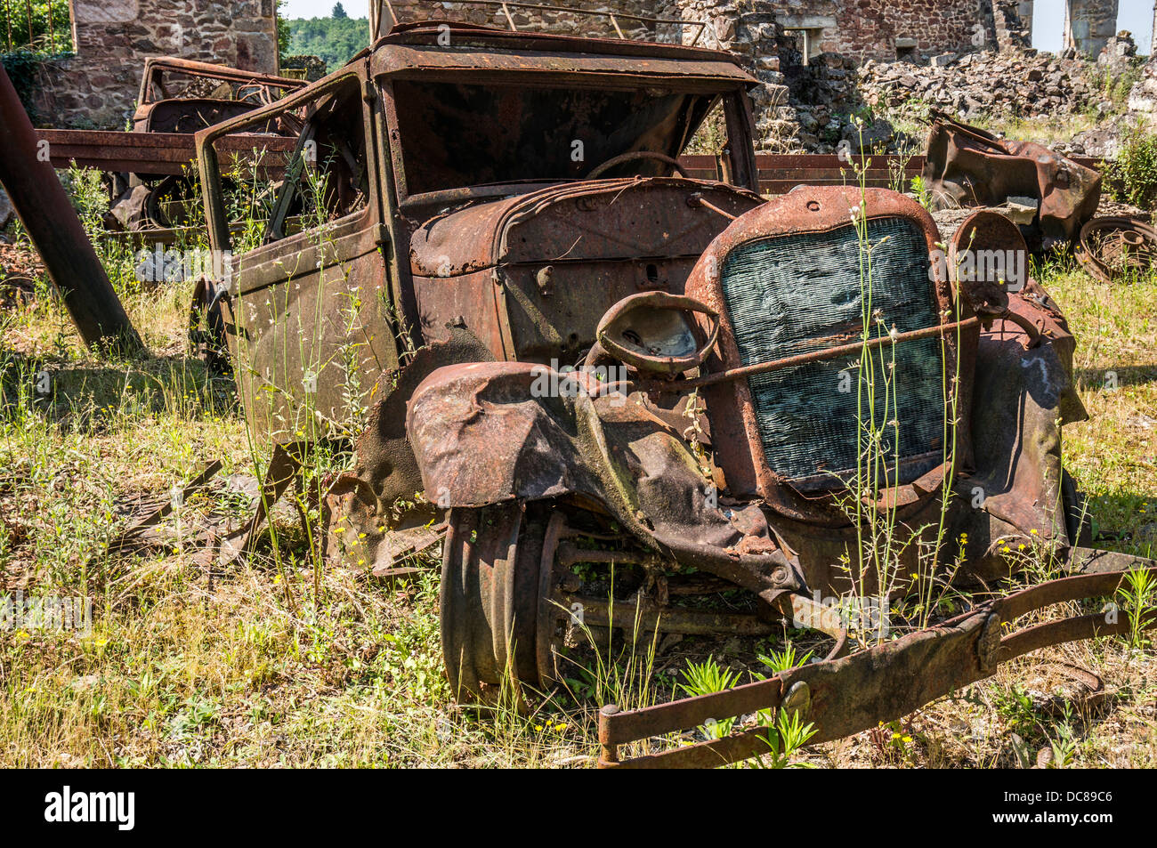 Eine verrostete Auto, enger in die Ruinen von Oradour-sur-Glane, Krieg, Massaker, Dordogne, Limousin, West, Südfrankreich. Stockfoto