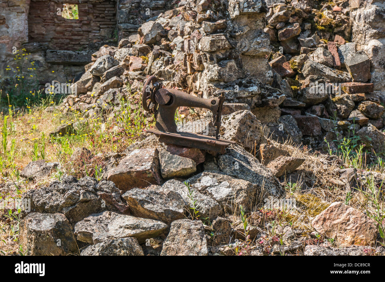 Eine ikonische Bild - Das verrostete Nähmaschine, in die Ruinen von Oradour-sur-Glane, Krieg, Massaker, Dordogne, Limousin Frankreich. Stockfoto