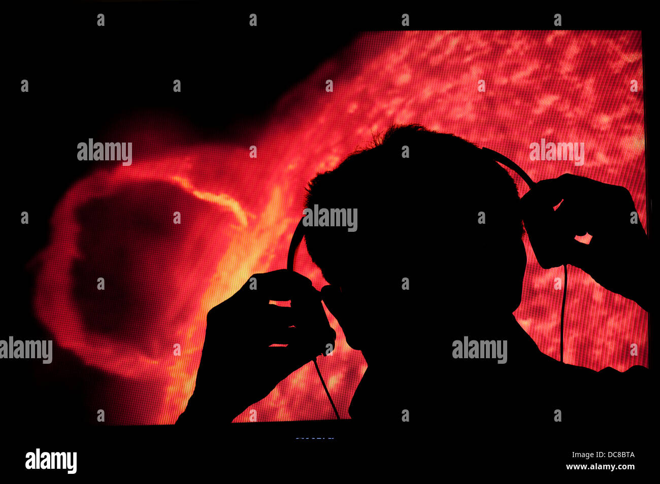 Mann-Wissenschaftler mit Kopfhörern Überwachung Klänge aus Sonne Stockfoto