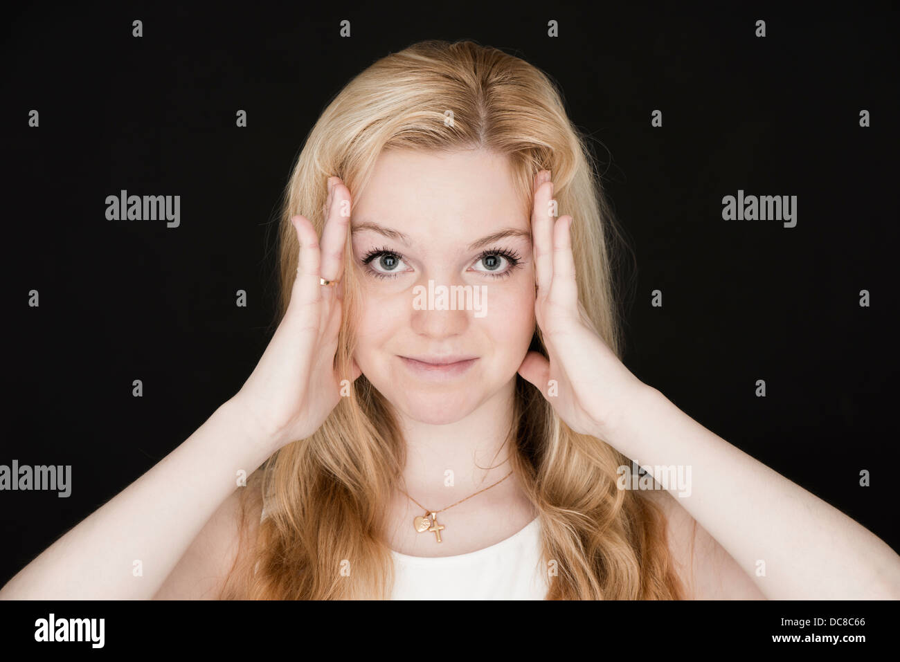 Junge blonde weibliche Teenager Blick in die Kamera und lächelnd Stockfoto