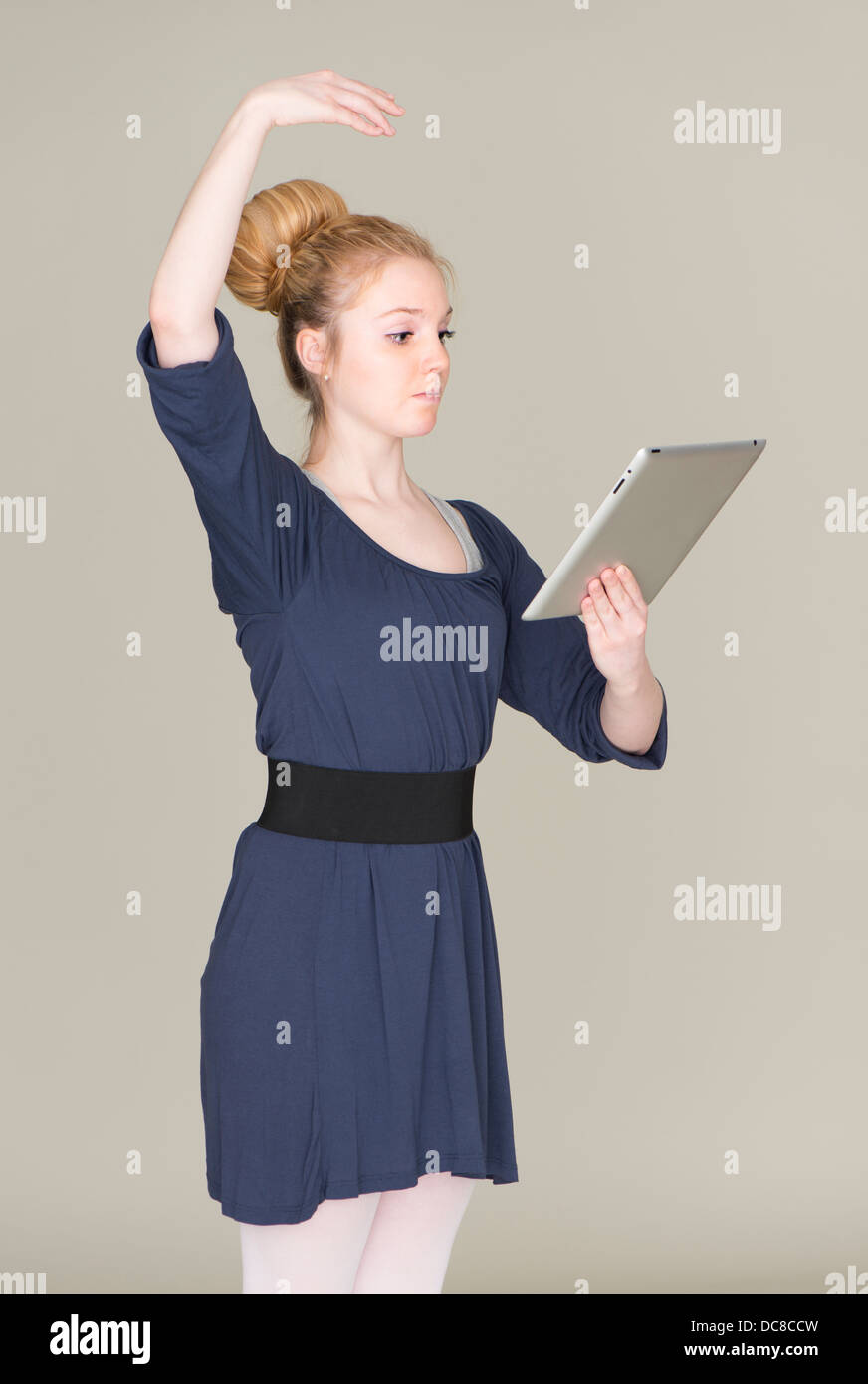 Junge blonde weibliche Teenager im Ballett Kleid mit einem TabletPC Stockfoto