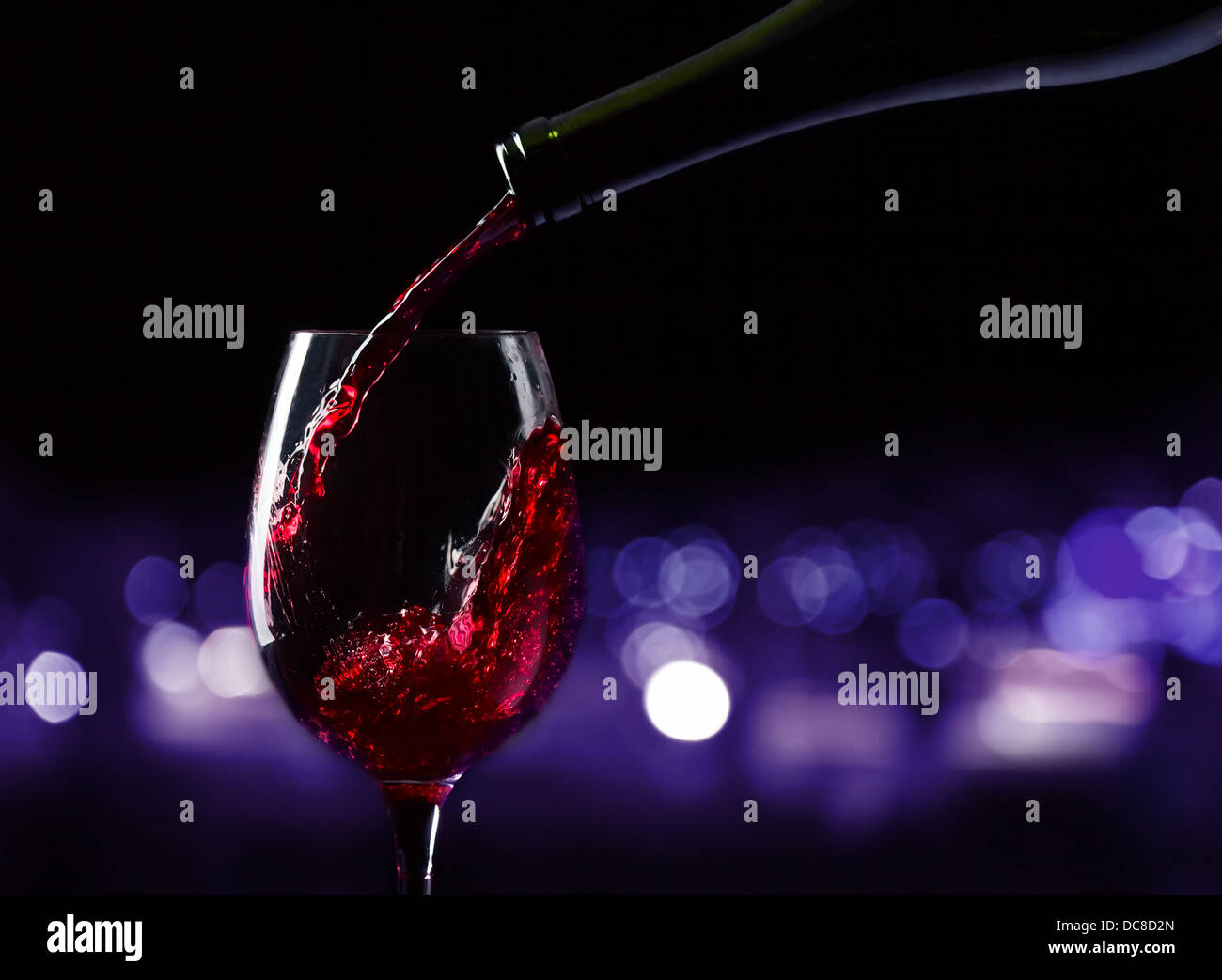 Flasche und Glas mit Rotwein auf einem schwarzen Hintergrund Stockfoto