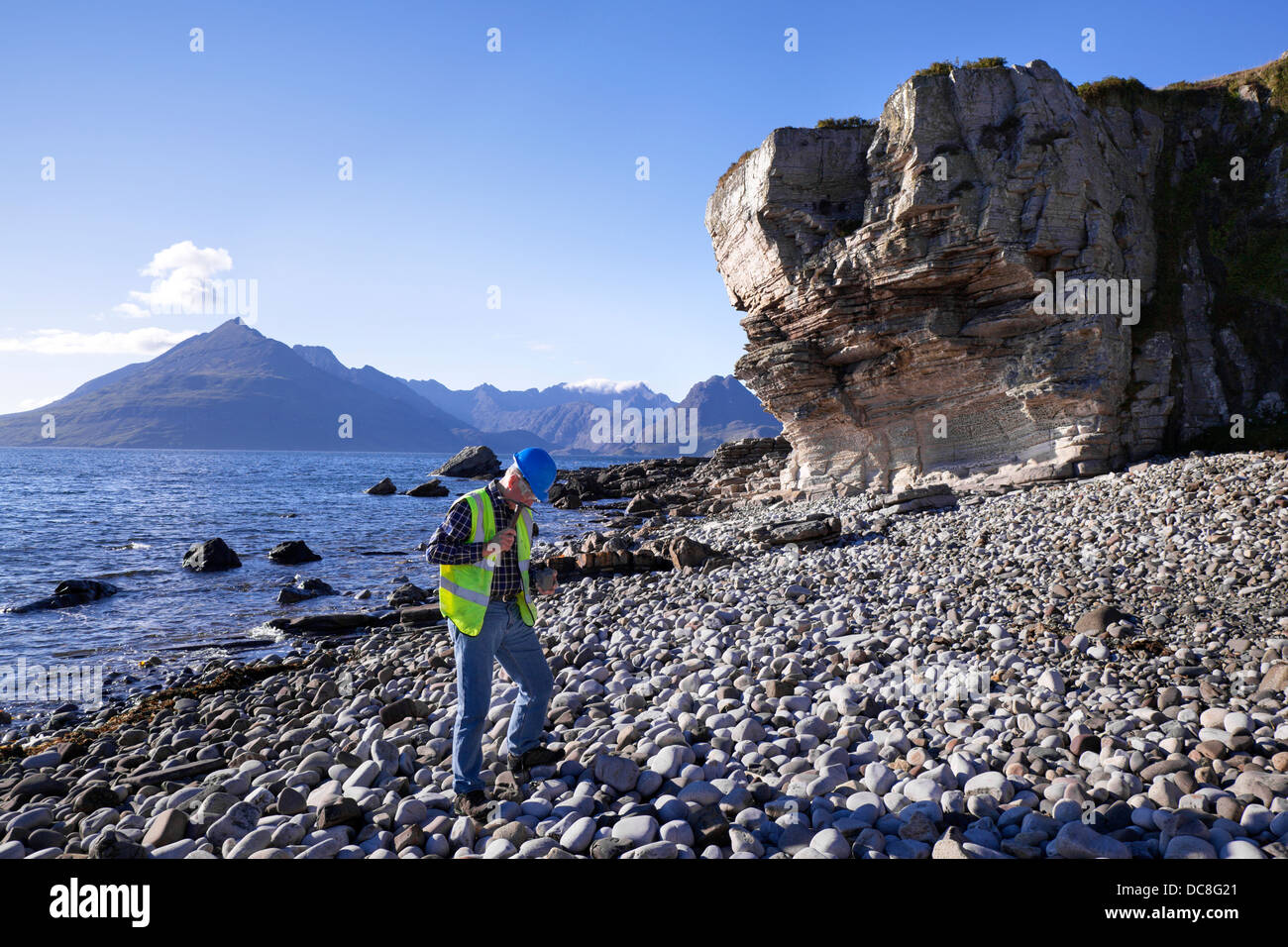 Ein Geologe am Pebble Beach & Lochside in Elgol. Die Cuillin-Hügel und -Hochländer über Loch Scavaig bis Loch Coruisk, Schottland, Großbritannien Stockfoto
