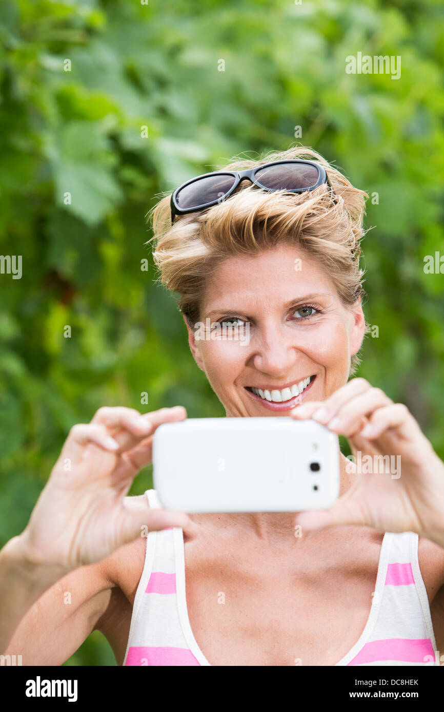 Junge Frau W34 nimmt ein Bild mit ihrem smartphone Stockfoto