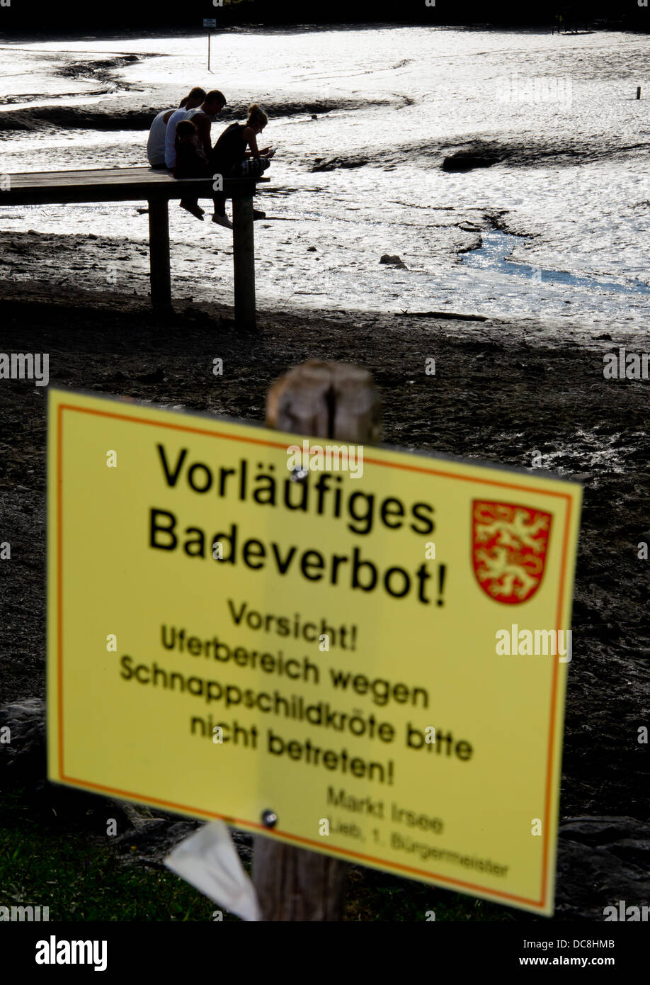 Zuschauer sitzen auf einem Steg auf der abgesperrten und entwässerte See Oggenrieder Weiher in Irsee bei Kaufbeuren, Deutschland, 12. August 2013. Ein Alligator-Schnappschildkröte etwas ein Junge ein paar Tage her. Der See war dann entleert, um die Schildkröte zu fangen. Foto: PETER KNEFFEL Stockfoto