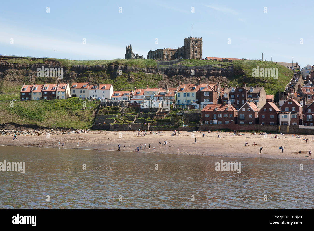 Menschen genießen den Strand von Whitby, befindet sich des Hafens und die Abtei sind im Hintergrund. Stockfoto