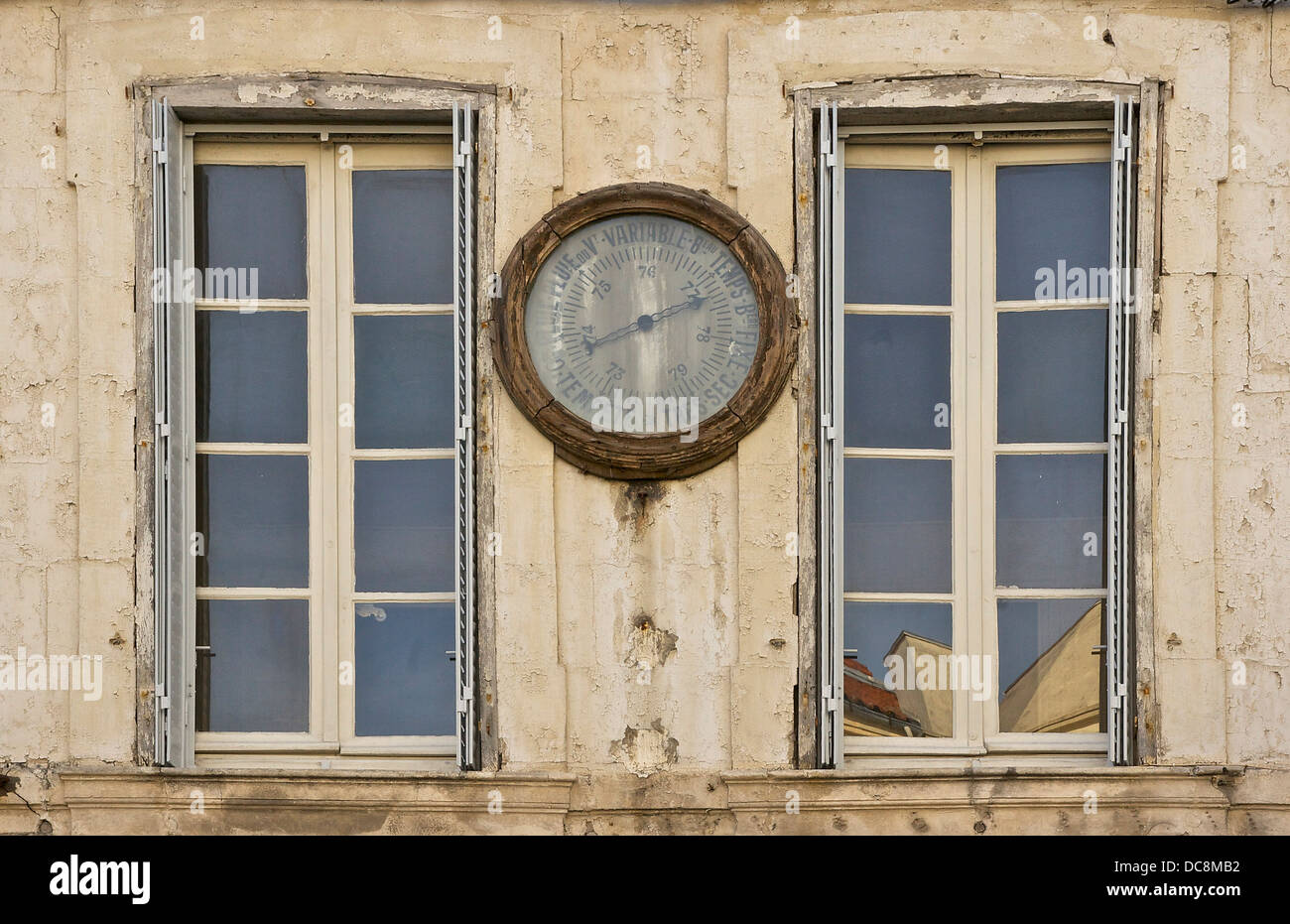 Ein Barometer zwischen zwei Fenstern, in einer Straße von La Rochelle, Frankreich. Stockfoto