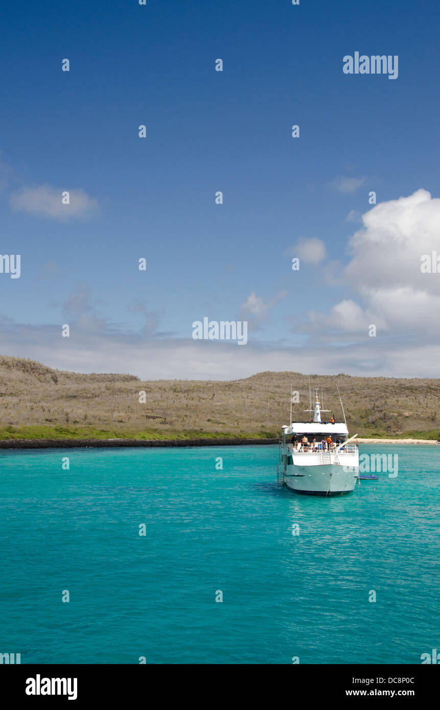 Ecuador, Galapagos, Santa Fe, Barrington Bucht. Kristallklare Bucht mit touristische Yacht entlang der Küste der Insel Santa Fe. Stockfoto