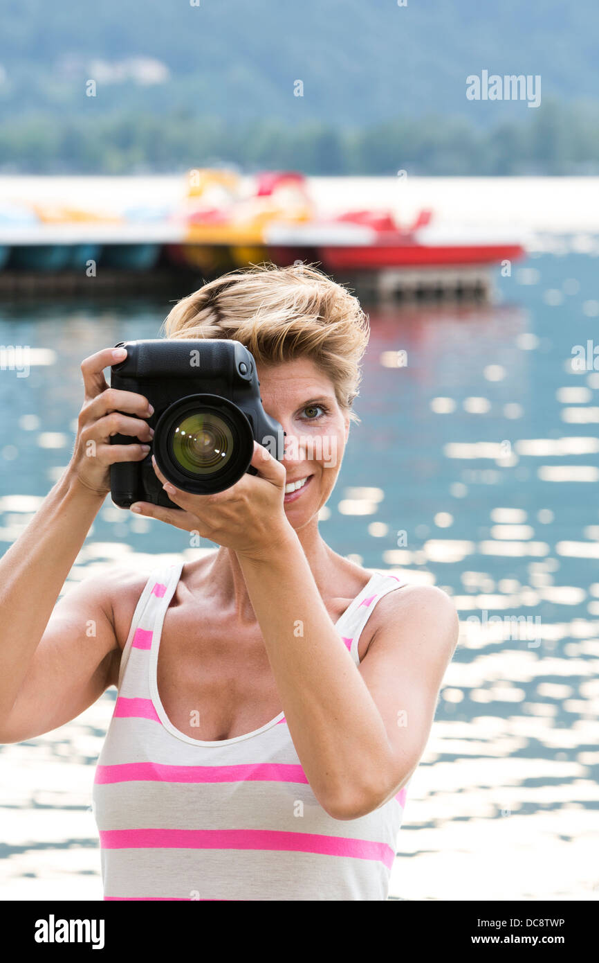 Junge Frau W34 im Urlaub nimmt ein Bild mit ihrer DSLR-Kamera Stockfoto