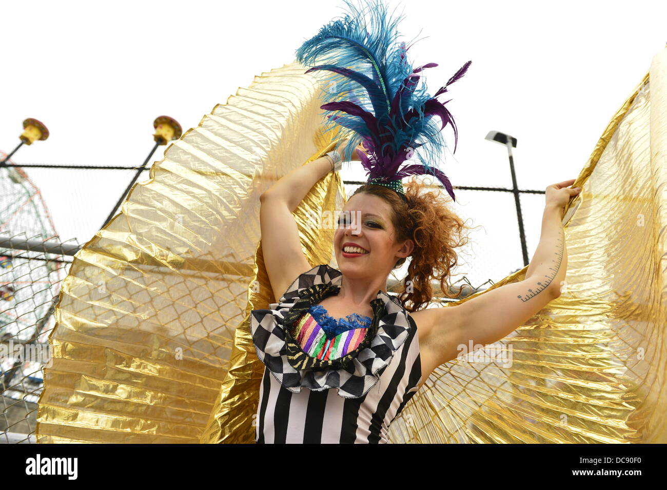 Brooklyn, New York, USA. 10. August 2013. Auf Coney Island trägt Stelzenläufer Walker KAE BURKE, der Dame Zirkus, ein Kostüm und Gold Kap Kostüm, wie geht sie hoch auf Stelzen. Stockfoto