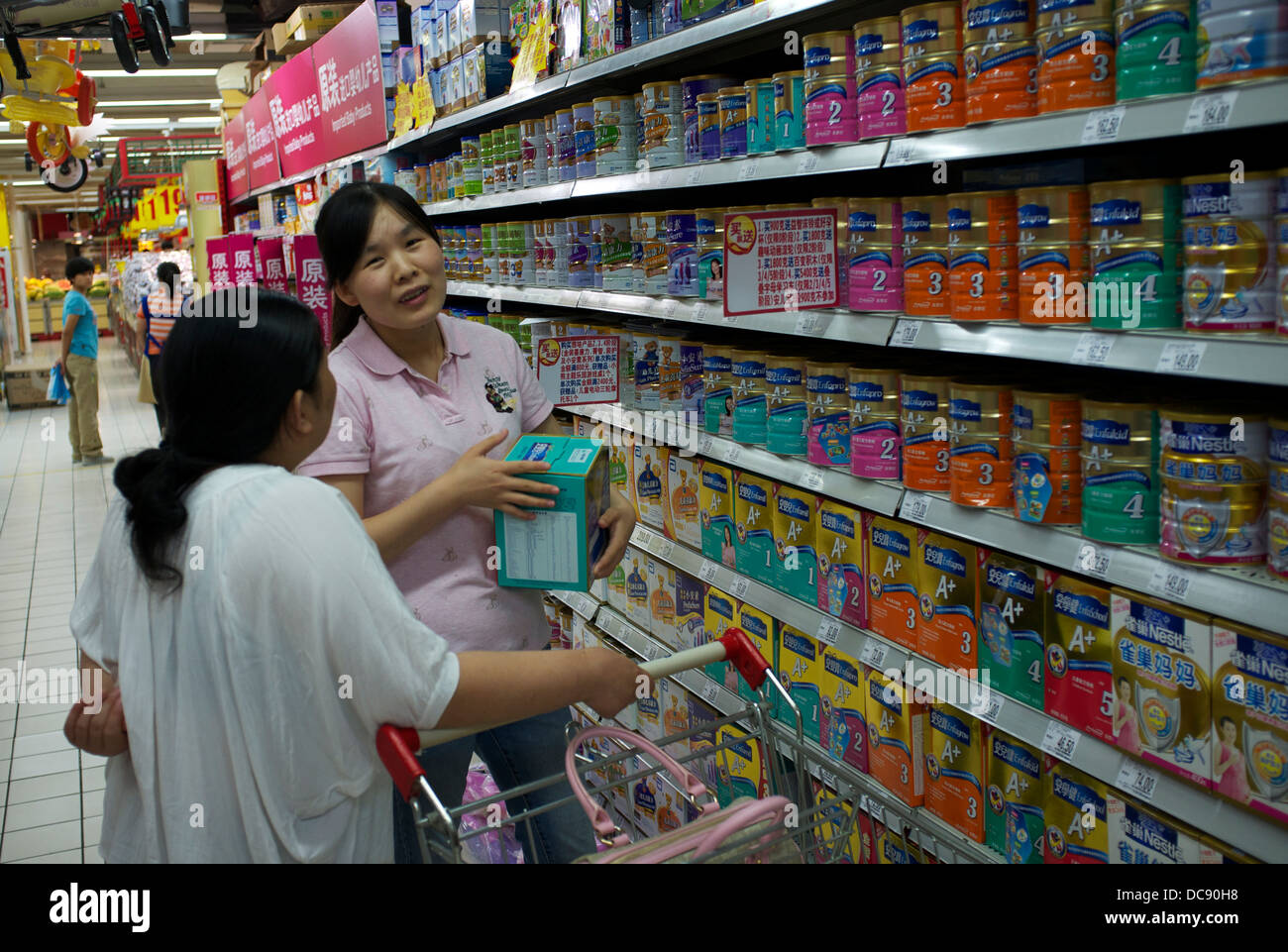 Eine chinesische Mutter nimmt eine Dose Enfamil von Mead Johnson Säuglingsmilch macht in einem Carrefour-Supermarkt in Peking, China. 2013 Stockfoto