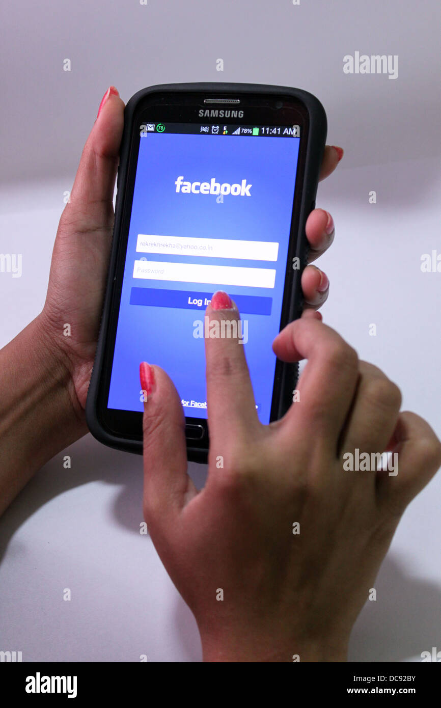 Frau mit Facebook auf einem Smartphone (Samsung Galaxy grand) Stockfoto