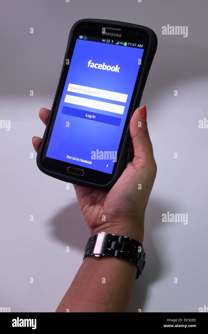 Frau mit Facebook auf einem Smartphone (Samsung Galaxy grand) Stockfoto