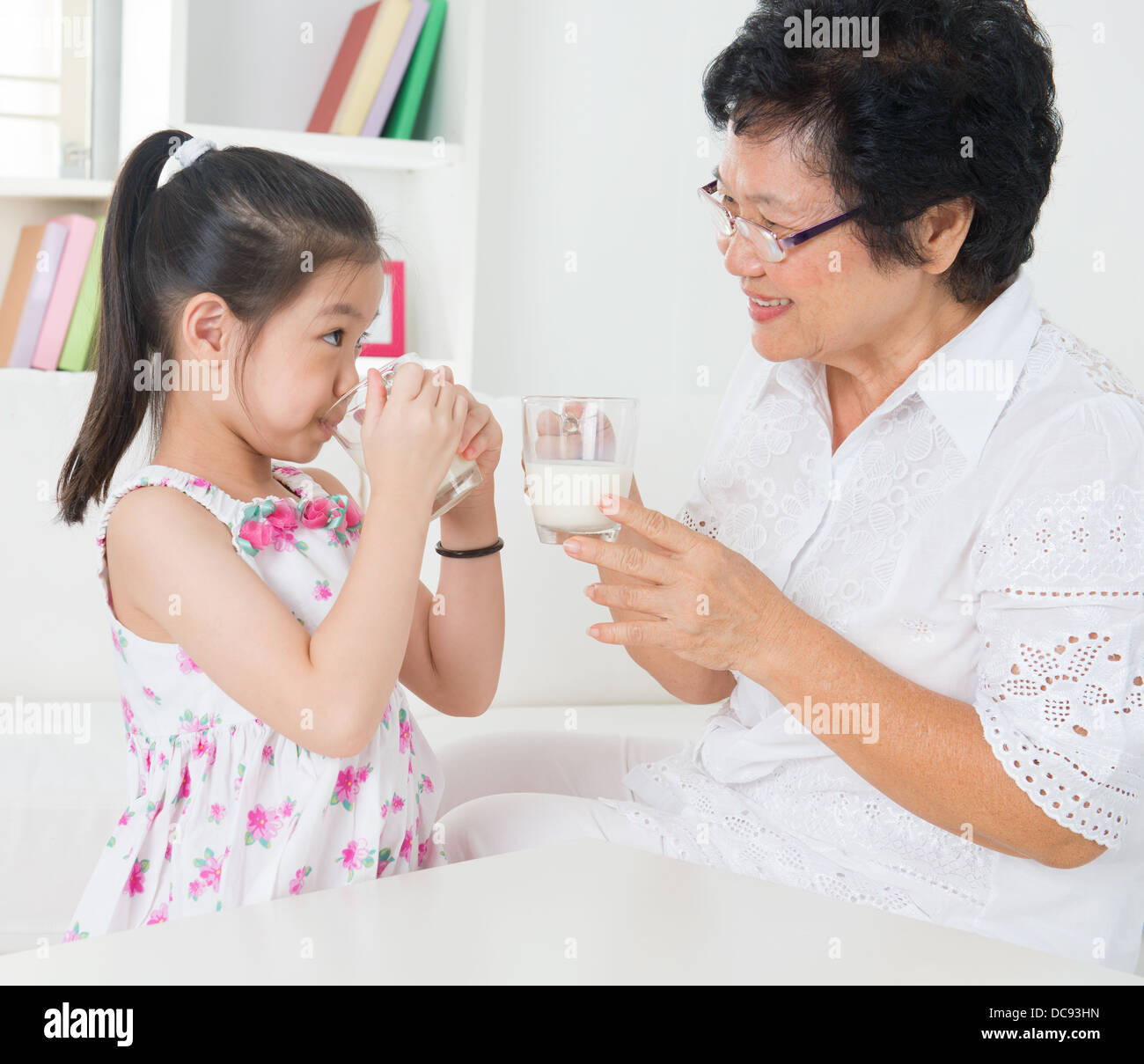 Milch zu trinken. Glücklich Multi Generationen asiatischen Familie zu Hause. Schöne Großmutter und Enkelin, medizinisches Konzept. Stockfoto