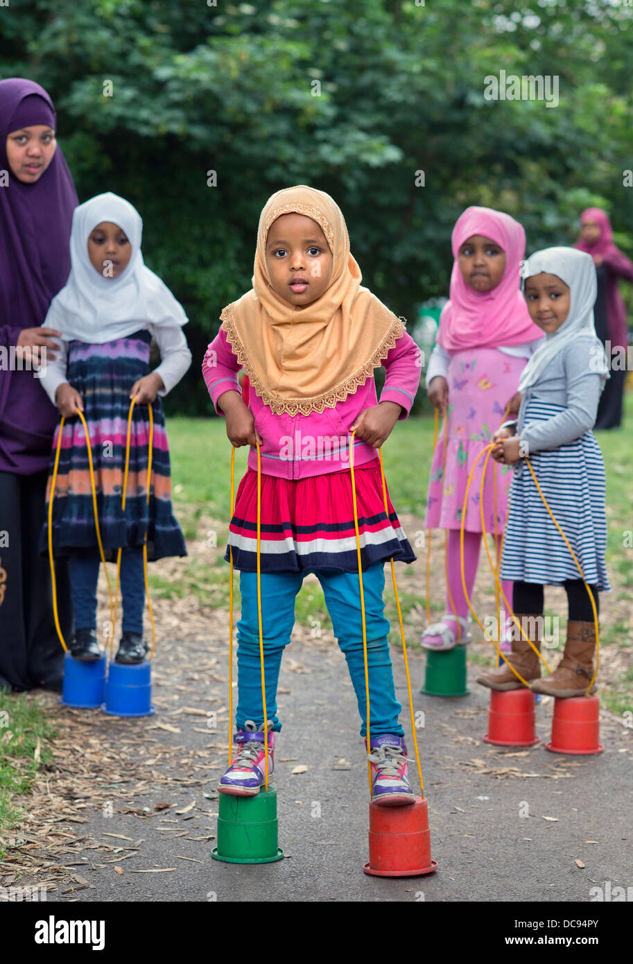 Der Kindergarten St. Pauls und Kinderhaus, Bristol UK - somalische Mädchen auf Stelzen auf dem Spielplatz spielen. Stockfoto