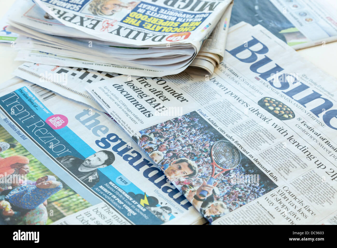 Britische Zeitungen auf einem Tisch ausgebreitet Stockfoto