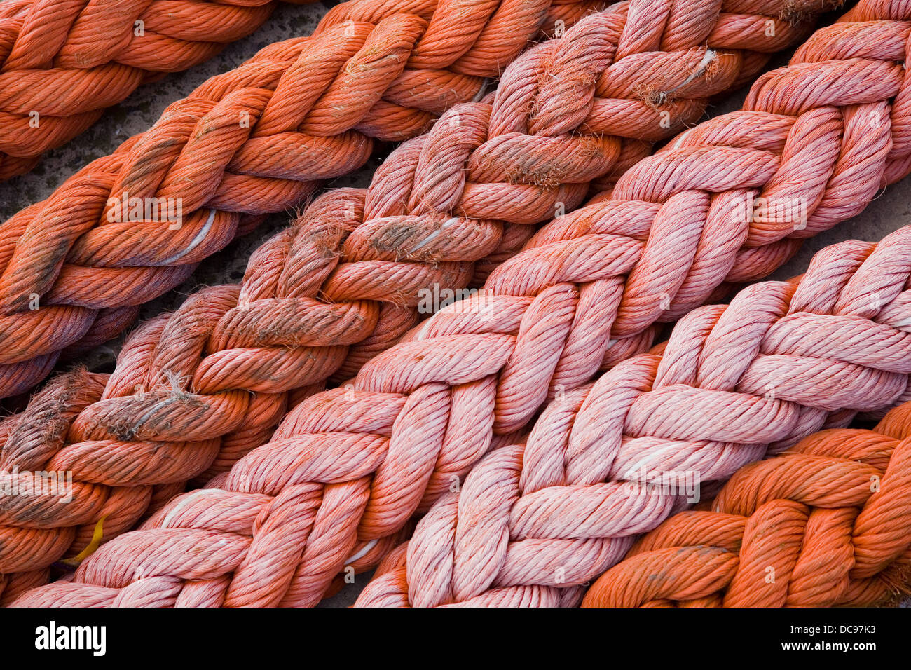 Nahaufnahme von dicke orange Seil angelegt in diagonalen Linien auf einem Deich, gebeizt mit Meersalz Stockfoto