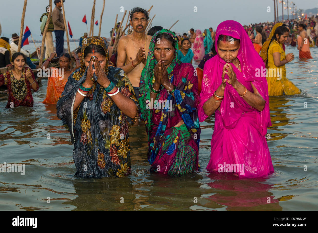 Frauen, die ein Bad in der Sangam, dem Zusammenfluss der Flüsse Ganges und Yamuna Saraswati, in den frühen Morgenstunden Kumbha Mela Stockfoto