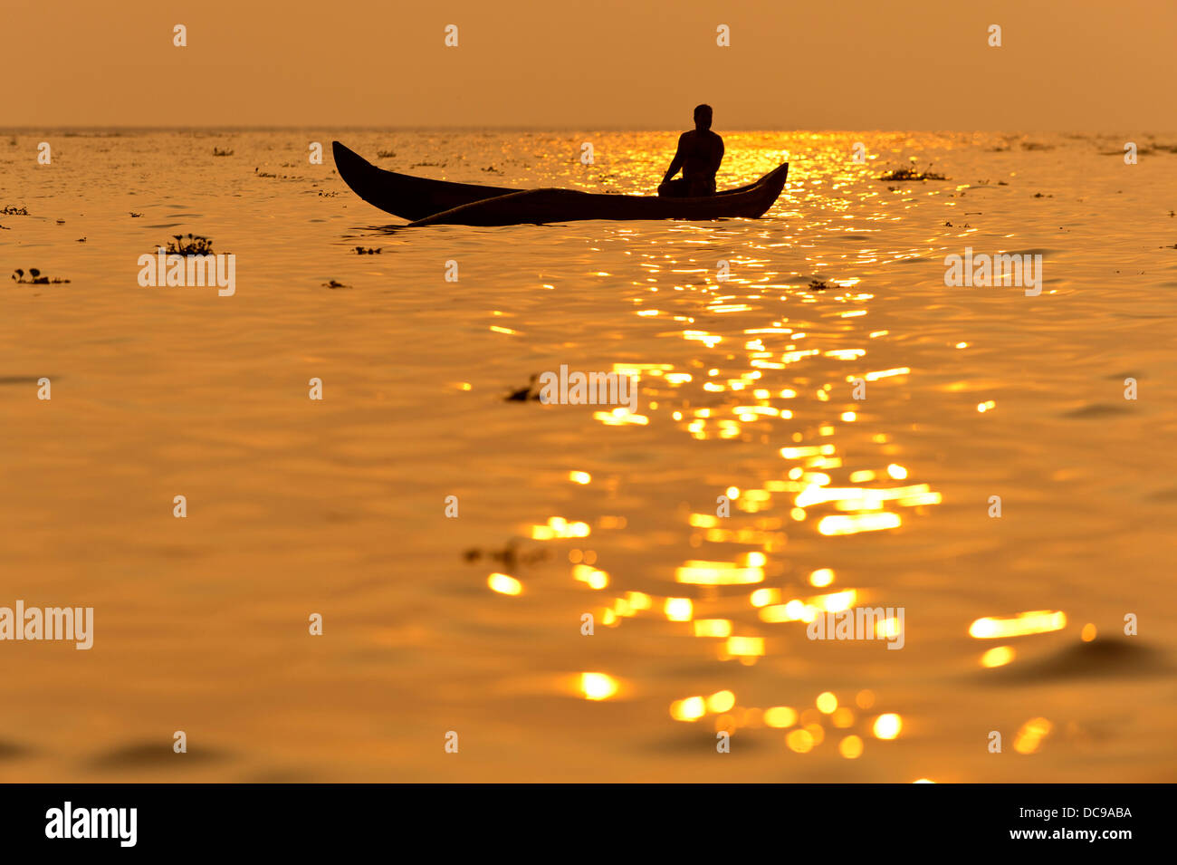 Fischer in seinem Boot bei Sonnenaufgang Stockfoto