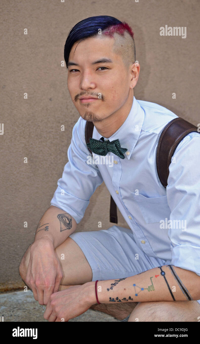 Porträt von einen jungen asiatischen Mann mit mehreren Tattoos und Haare mit blauen und roten Färbung. Im Stadtteil East Village von Manhattan Stockfoto