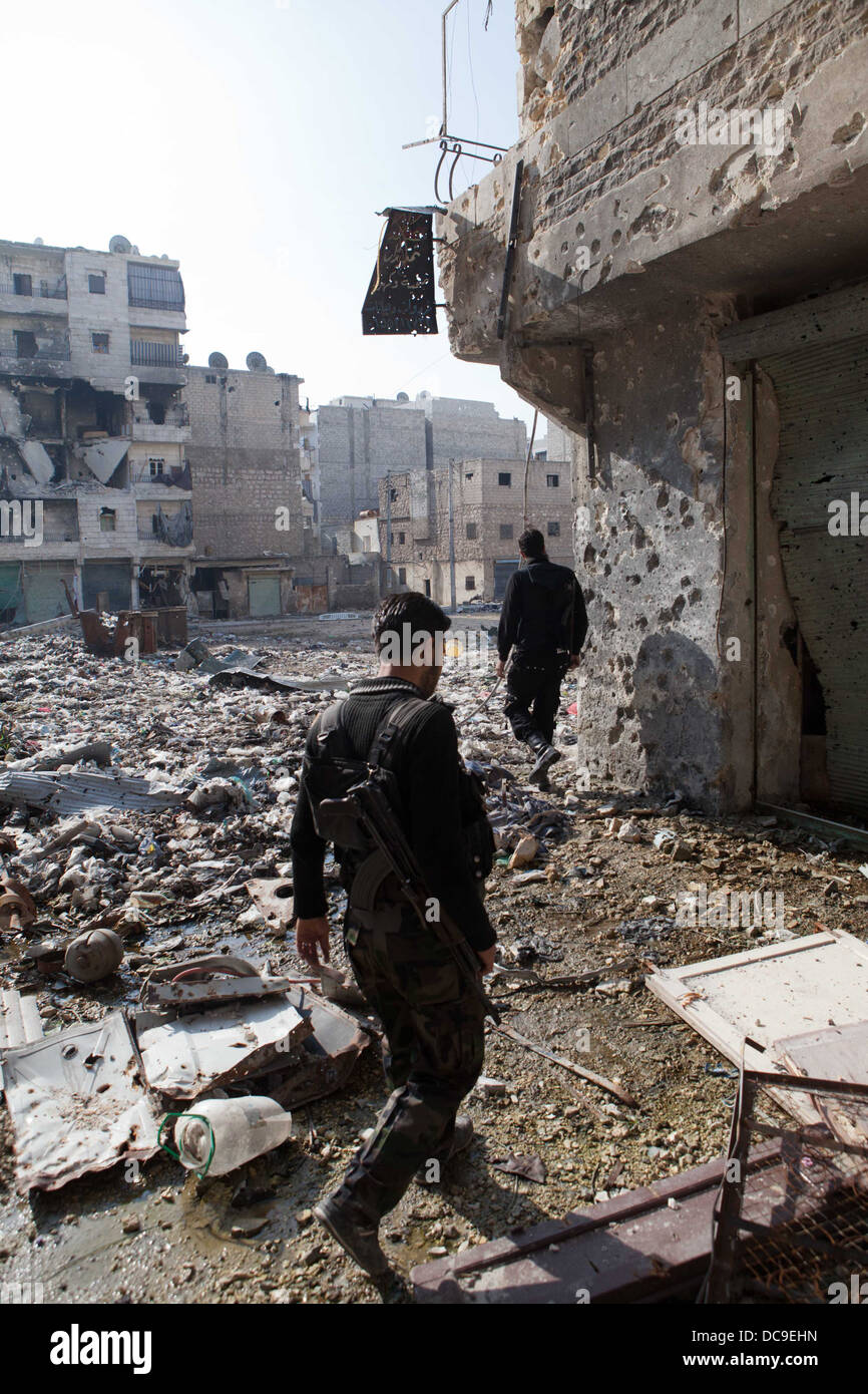 29. November 2012 - Aleppo, Syrien: Freie Syrische Armee Kämpfer zu Fuß durch den Krieg verwüsteten Straßen in Amaria. Stockfoto