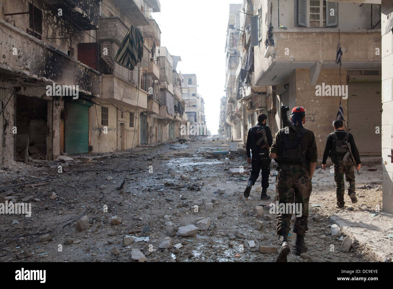 29. November 2012 - Aleppo, Syrien: Freie Syrische Armee Kämpfer zu Fuß durch den Krieg verwüsteten Straßen in Amaria. Stockfoto