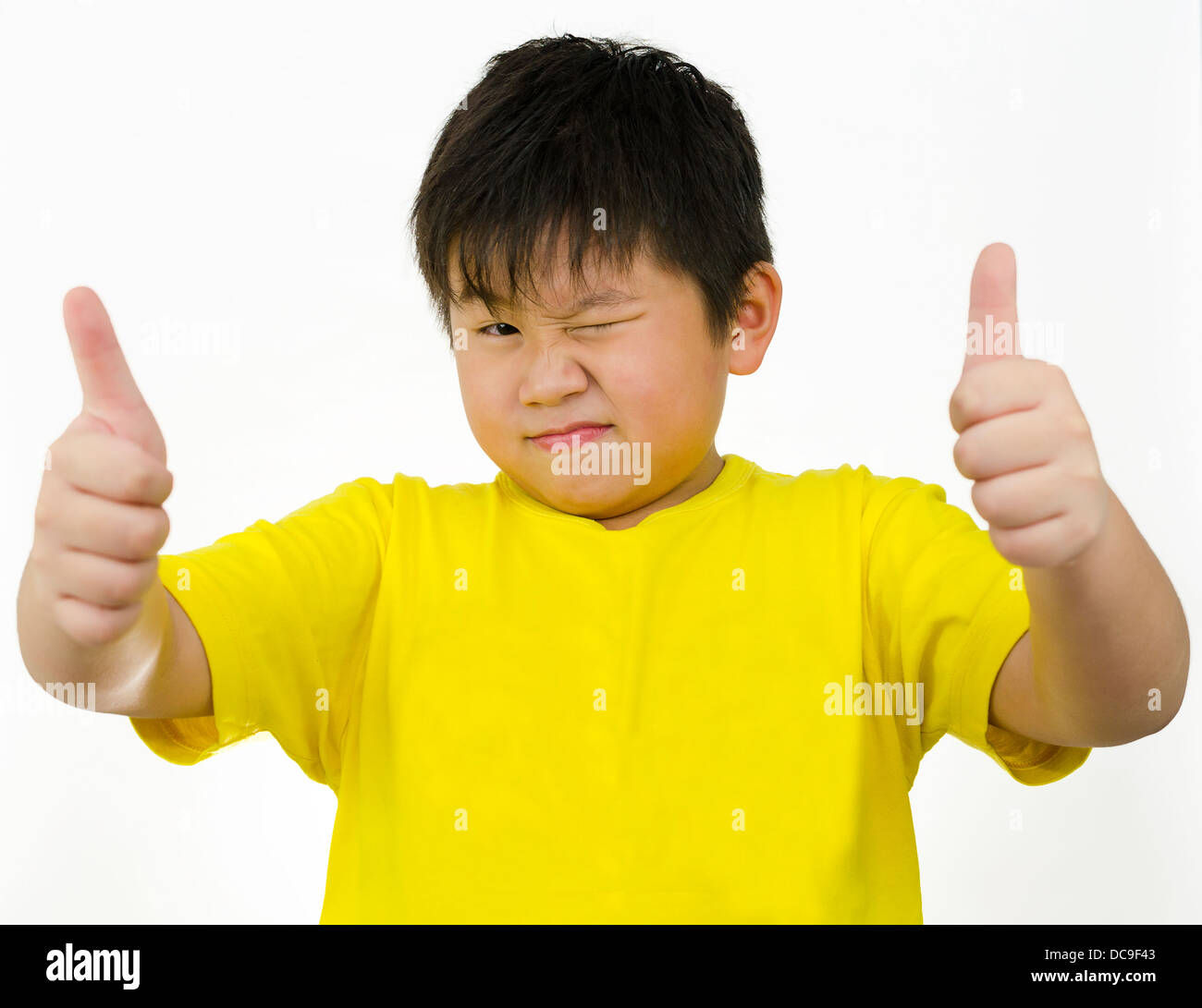 ein chinesischer Junge mit seinem Daumen oben auf weißem Hintergrund Stockfoto