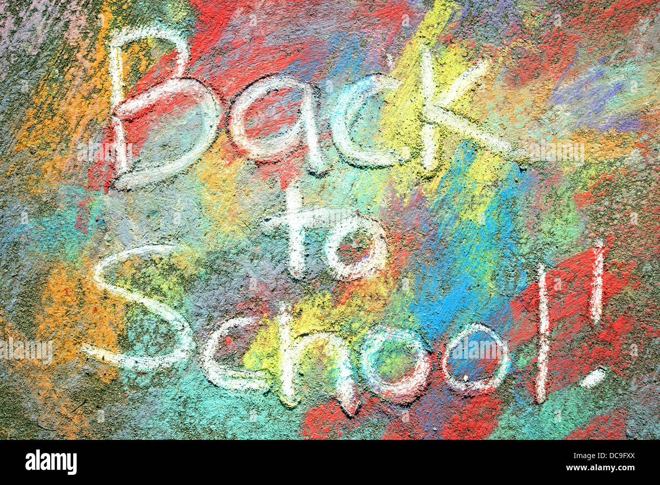 Die Worte wieder in die Schule sind in weißen Bürgersteig Kreide auf einem Hintergrund von Regenbogenfarben Tye-Dye gezeichnet auf dem Bürgersteig geschrieben. Stockfoto