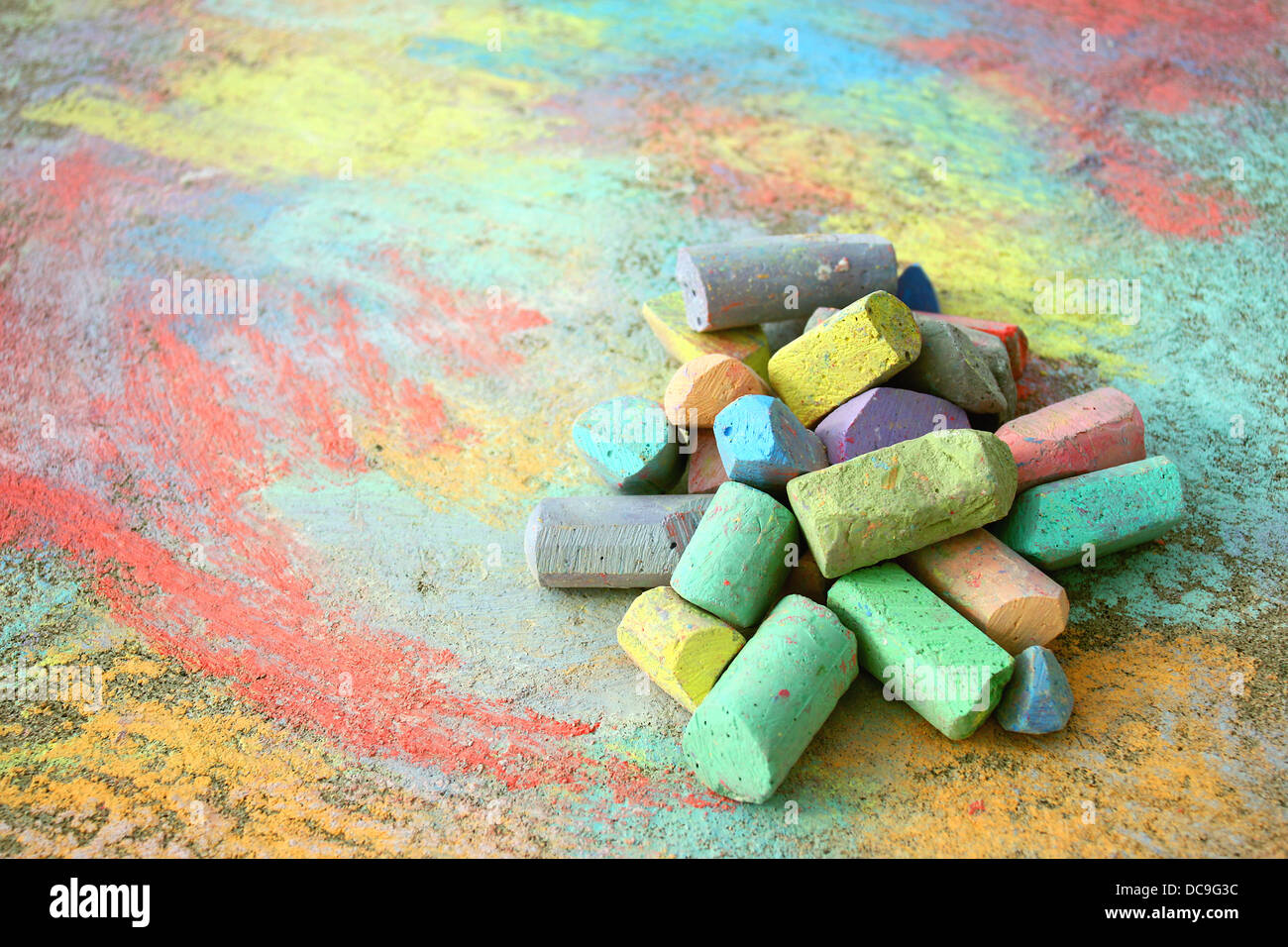 eine Sammlung von bunten Bürgersteig Kreide ist auf eine Regenbogen-Zeichnung, draußen auf dem Bürgersteig aufgetürmt. Stockfoto