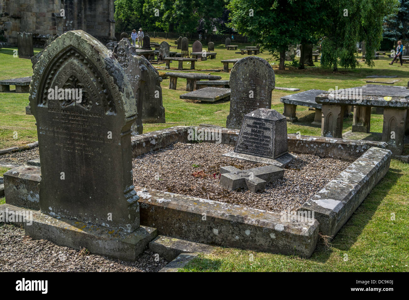 Grabsteine in Friedhof mit einem gefallenen Kreuz am Boden Stockfoto