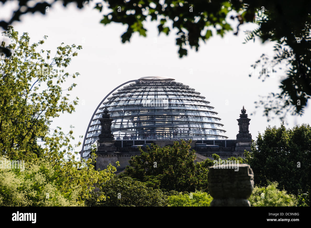 Die Reichstagskuppel, entworfen von dem Architekten Sir Norman Foster, umrahmt von Bäumen - Berlin-Deutschland Stockfoto