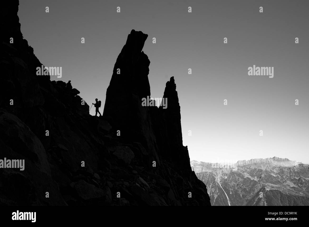 Seitliche Sicht auf Bergsteiger, Kletterer, Silhouette auf dem Grat in der Bergwelt. Stockfoto