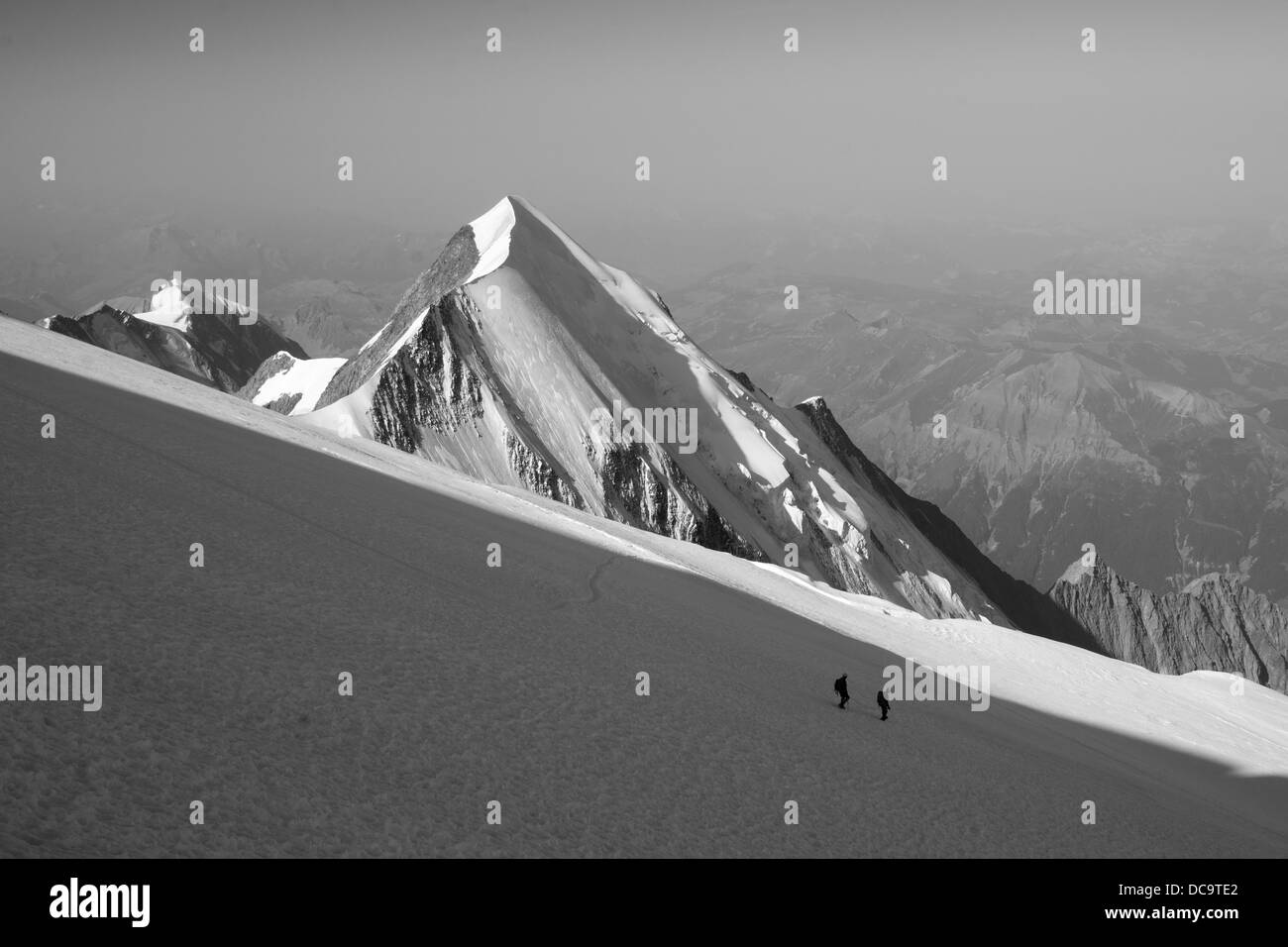 Team von zwei Bergsteiger beim Abstieg vom Mont Blanc an den Hängen des Dome du Gouter-Pyramid Peak ist im Hintergrund zu sehen. Stockfoto