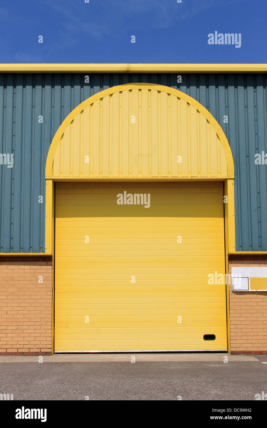 Moderne Lagerhalle mit gewölbten gelbe Tür außen. Stockfoto