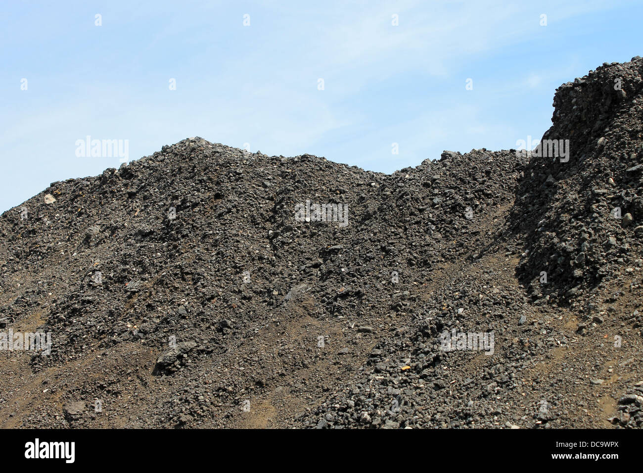 Seitenansicht der Haufen Kohle mit blauem Himmelshintergrund. Stockfoto